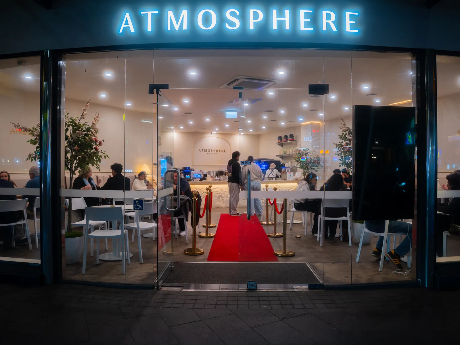 Atmosphere lit up at night, guests seated inside the Newmarket store