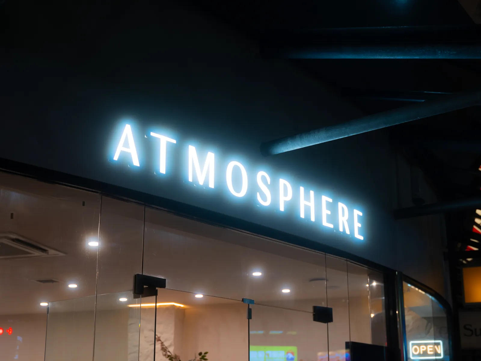 The illuminated Atmosphere sign glowing on Remuera Road at night