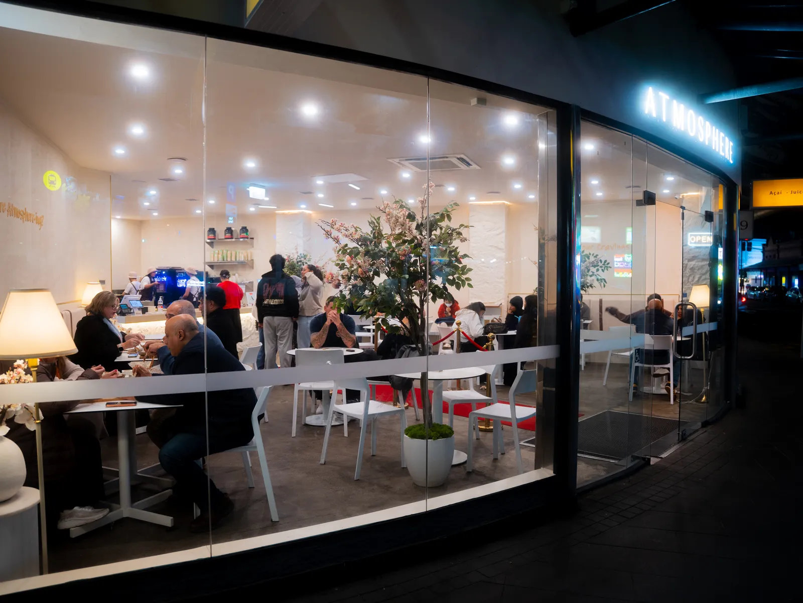 Atmosphere busy after dark, diners inside, seen from the street